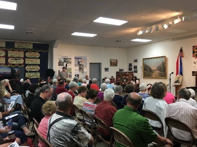 A meeting with many people sitting and listening