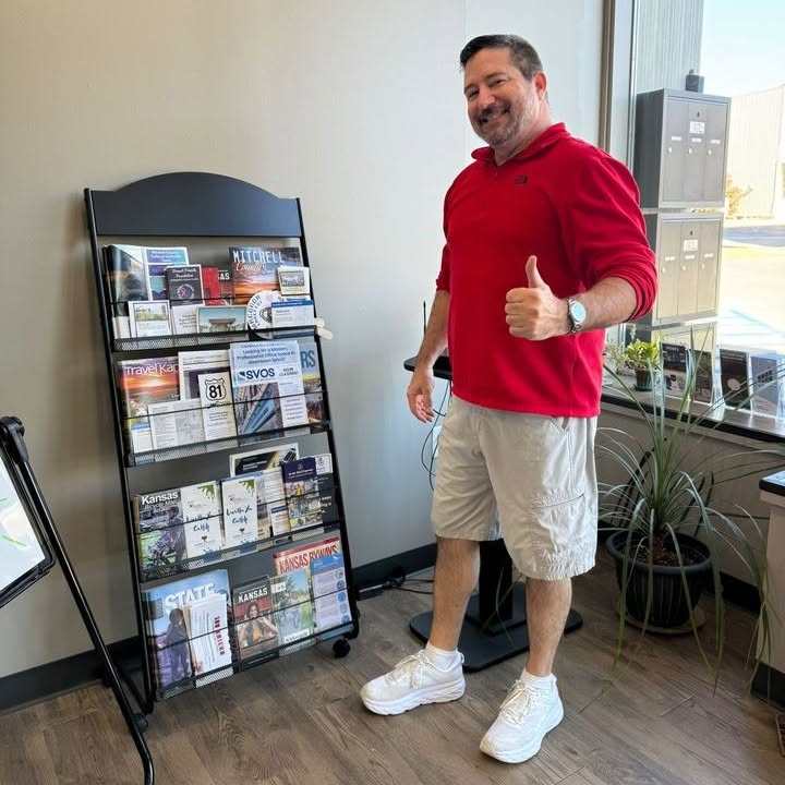Man giving thumbs up near brochure rack
