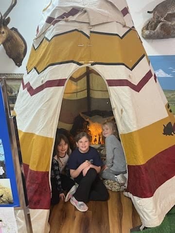 Three girls in a tee pee.